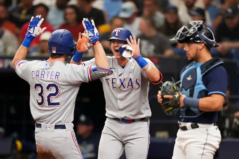 Texas Rangers left fielder Evan Carter celebrates with third baseman Josh Jung  after...