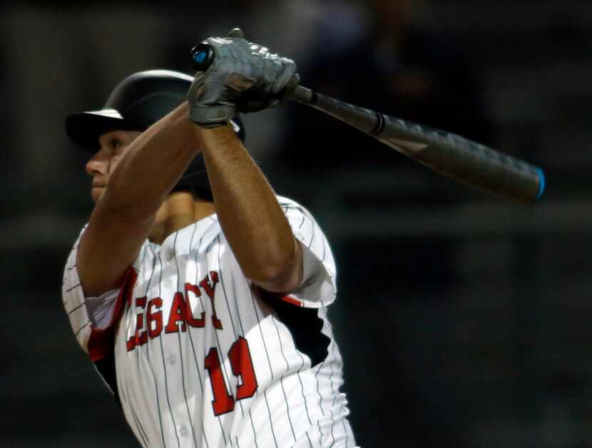 Mansfield Legacy catcher Nate Rombach (19) drives a fastball deep toward the outfield wall...