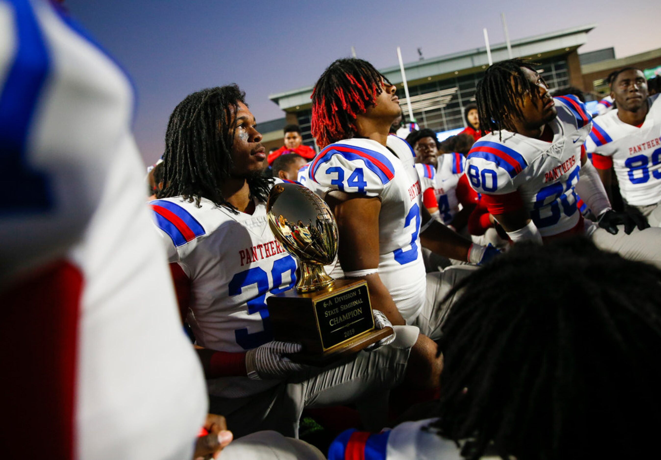 Duncanville linebacker Jordan Chapple (38) holds onto the trophy as head coach Reginald...