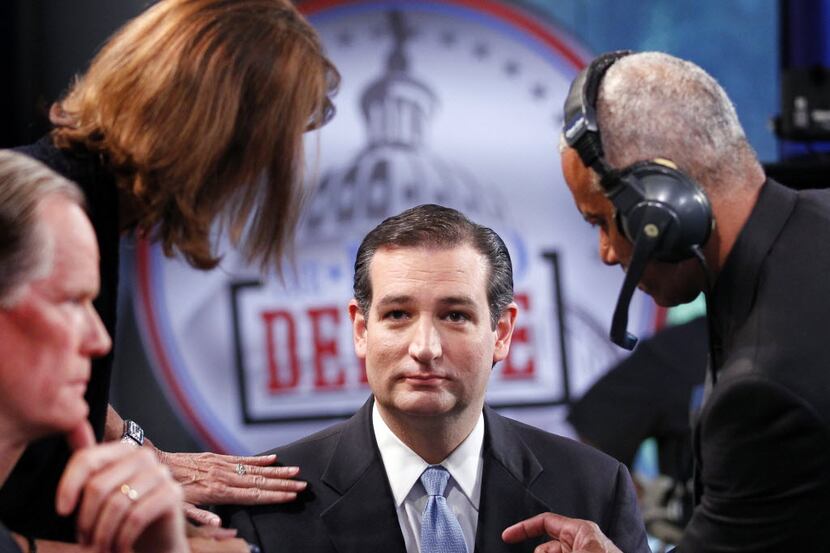 U.S. Senate Republican candidate Ted Cruz has his makeup put on and his microphone adjusted...