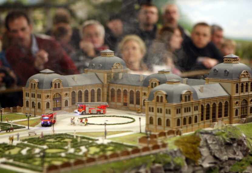 Visitors look at an animated scenery of fire fighting vehicles arriving at a burning castle...