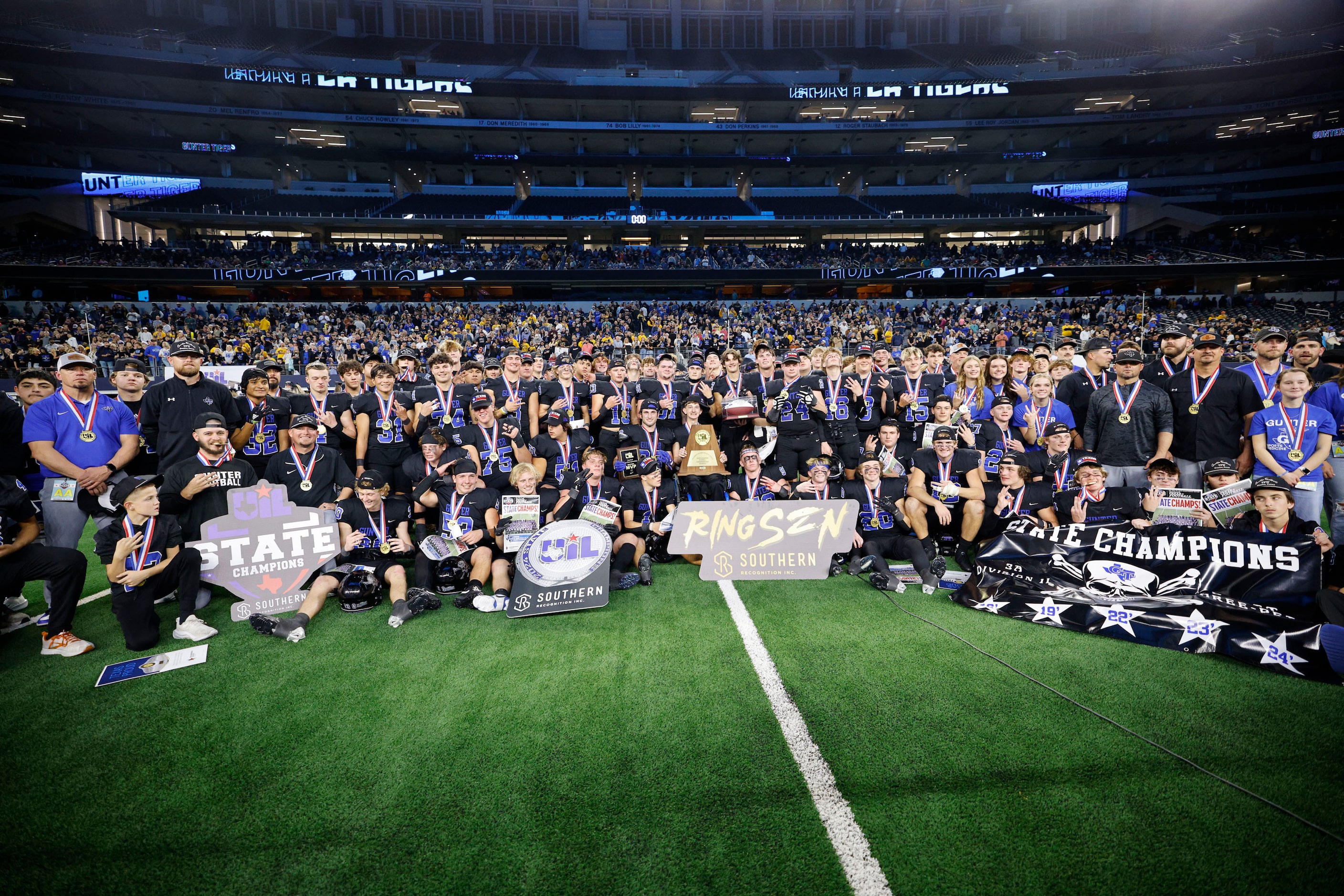 Gunter players and coaches pose for a photo after their 28-0 victory against Woodville at...