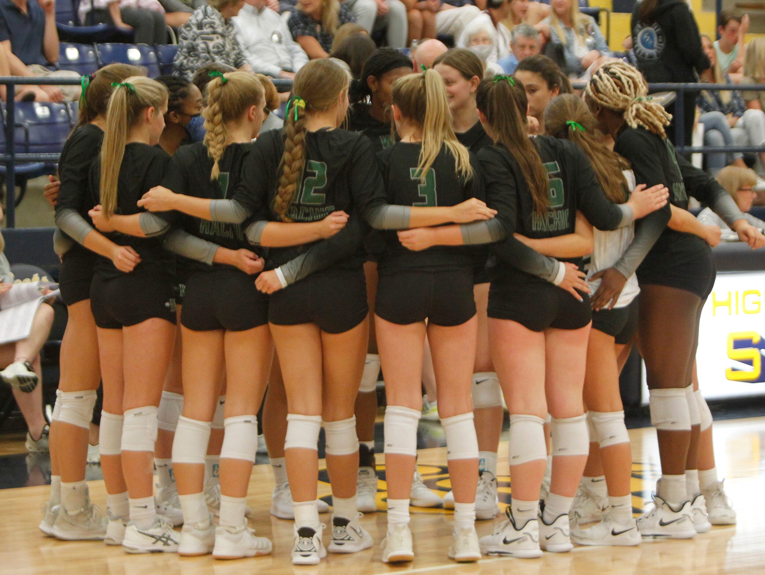 Waxahachie players huddle during a timeout in the 2nd set of their match against Highland...