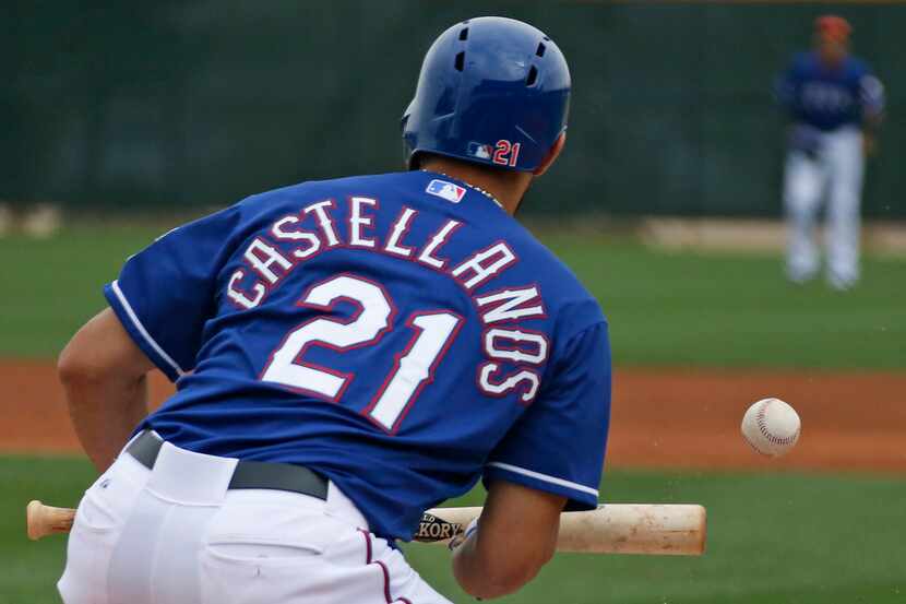 Texas outfielder  Alex Castellanos lays down a bunt during Texas Rangers baseball spring...