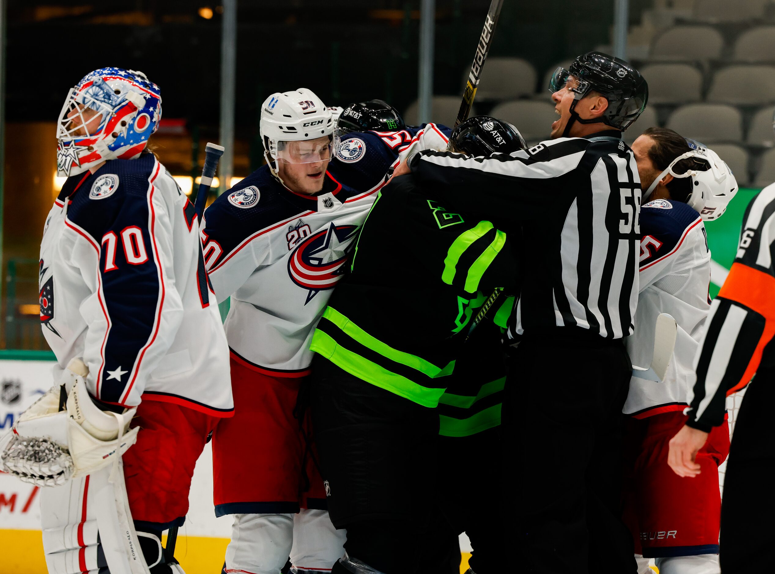 Linesman Ryan Gibbons (58) stops a fight between Dallas Stars and Columbus Blue Jackets...