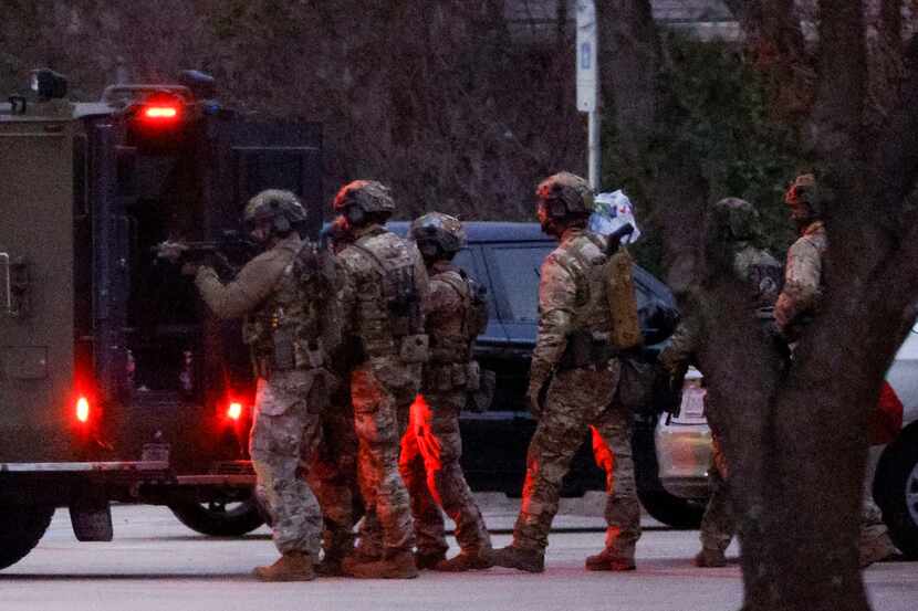 Members of the FBI prepare to deliver water and food to hostages while conducting SWAT...