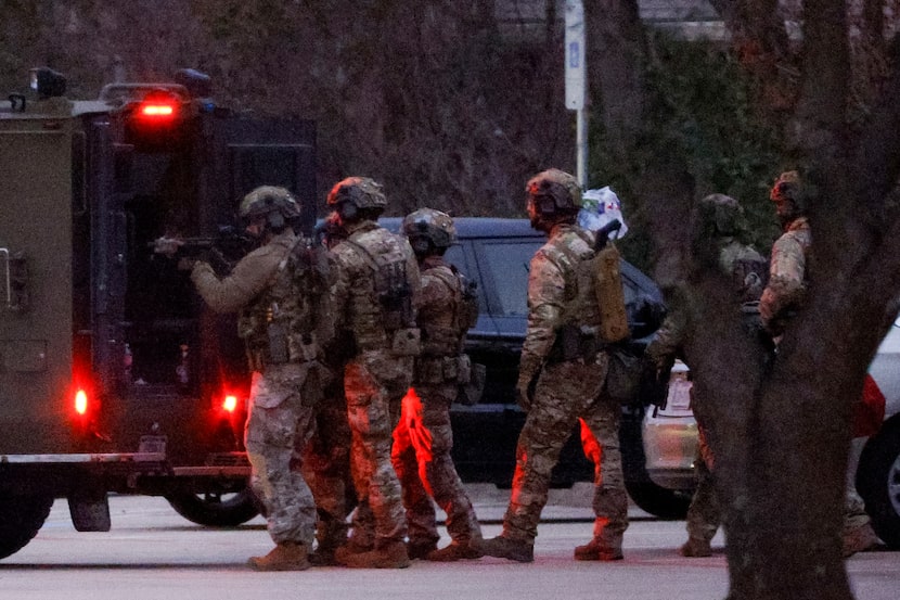 Members of the FBI prepare to deliver water and food to hostages while conducting SWAT...