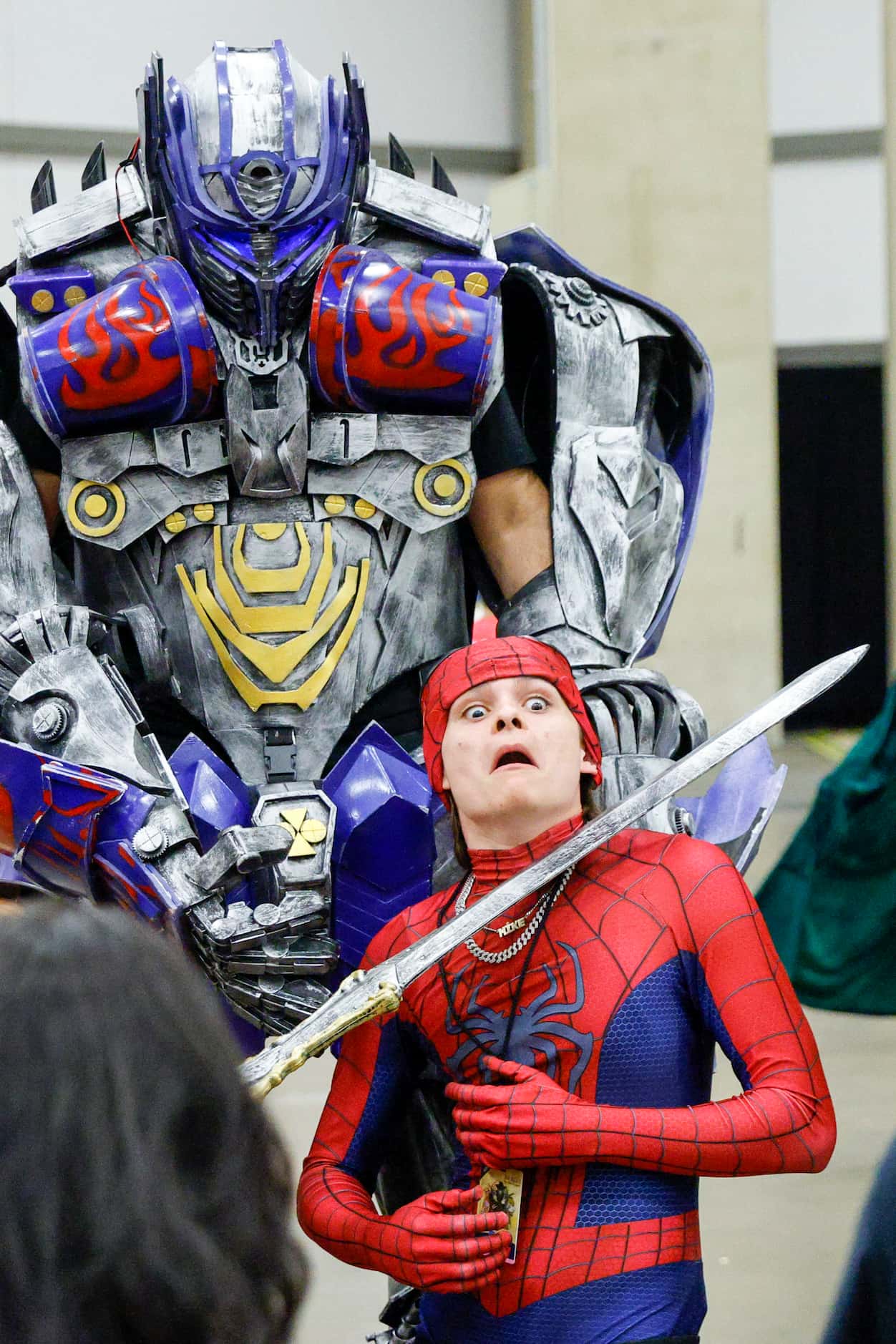 Aiden Rhinehart dressed as Spiderman poses for a photo with Adam Dacca dressed as Optimus...