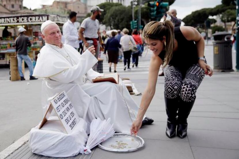 Plisko Julius, a Pope John Paul II impersonator from Slovakia, accepted a tourist’s offering...