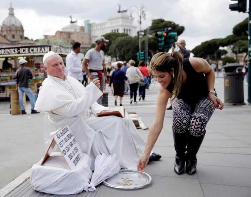 Plisko Julius, a Pope John Paul II impersonator from Slovakia, accepted a tourist’s offering...