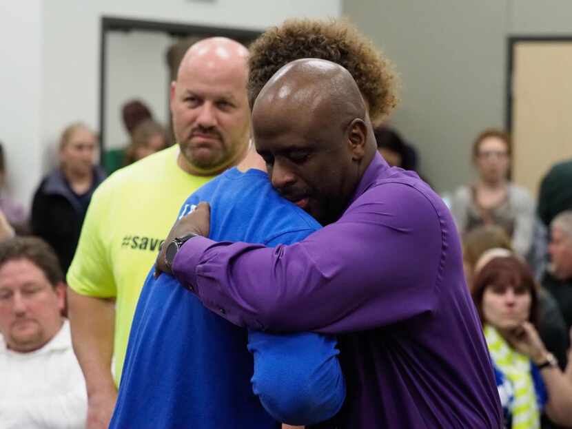 Krum High assistant principal Bernard Lightfoot (right)  is consoled by supporters after his...