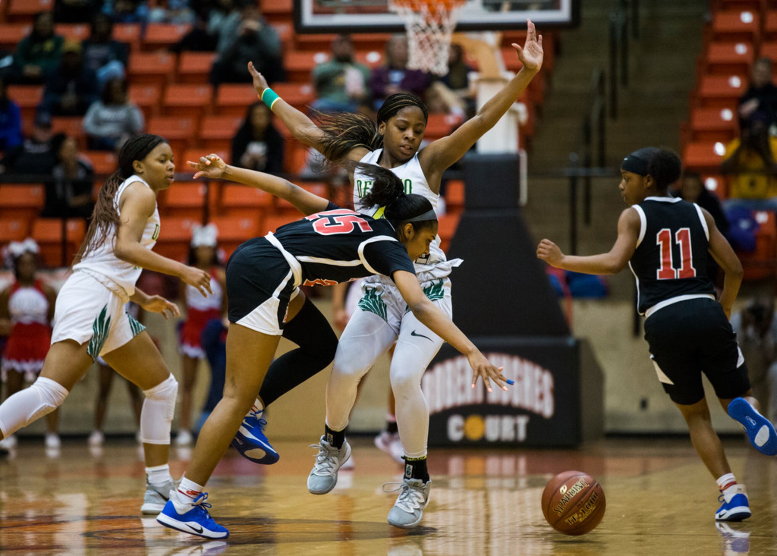 Duncanville's Deja Kelly (25) is tripped up by DeSoto's Ja'Mia Harris (4) during the first...