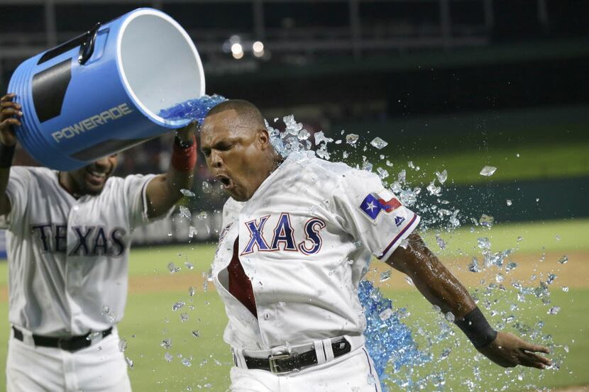Texas Rangers Adrian Beltre, right, gets doused by teammate Elvis Andrus after Beltre hit a...