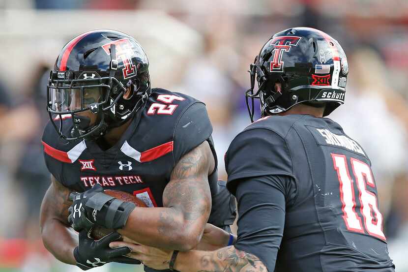 Texas Tech's Nic Shimonek (16) hands the ball off to Tre King (24)  during an NCAA college...