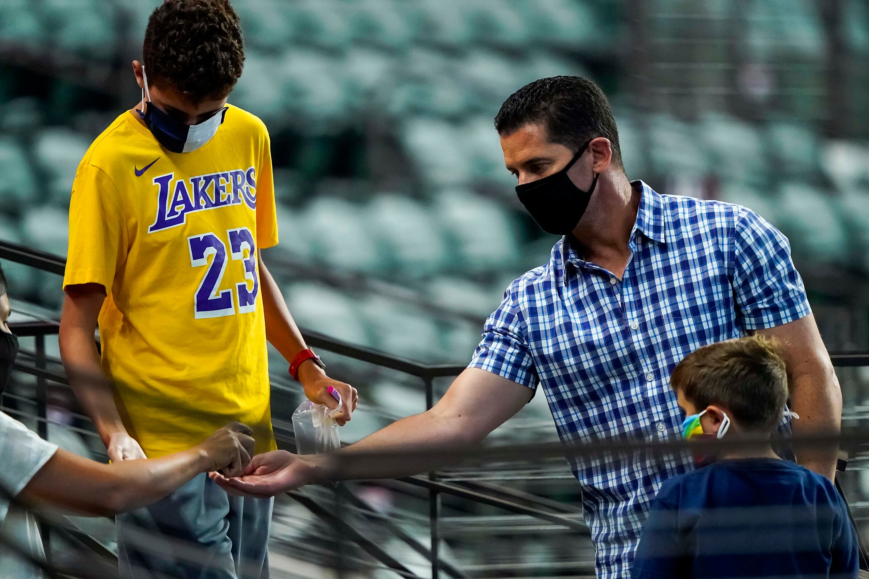 Former Rangers player Michael Young gets a squirt of hand sanitizer as he watches  an...
