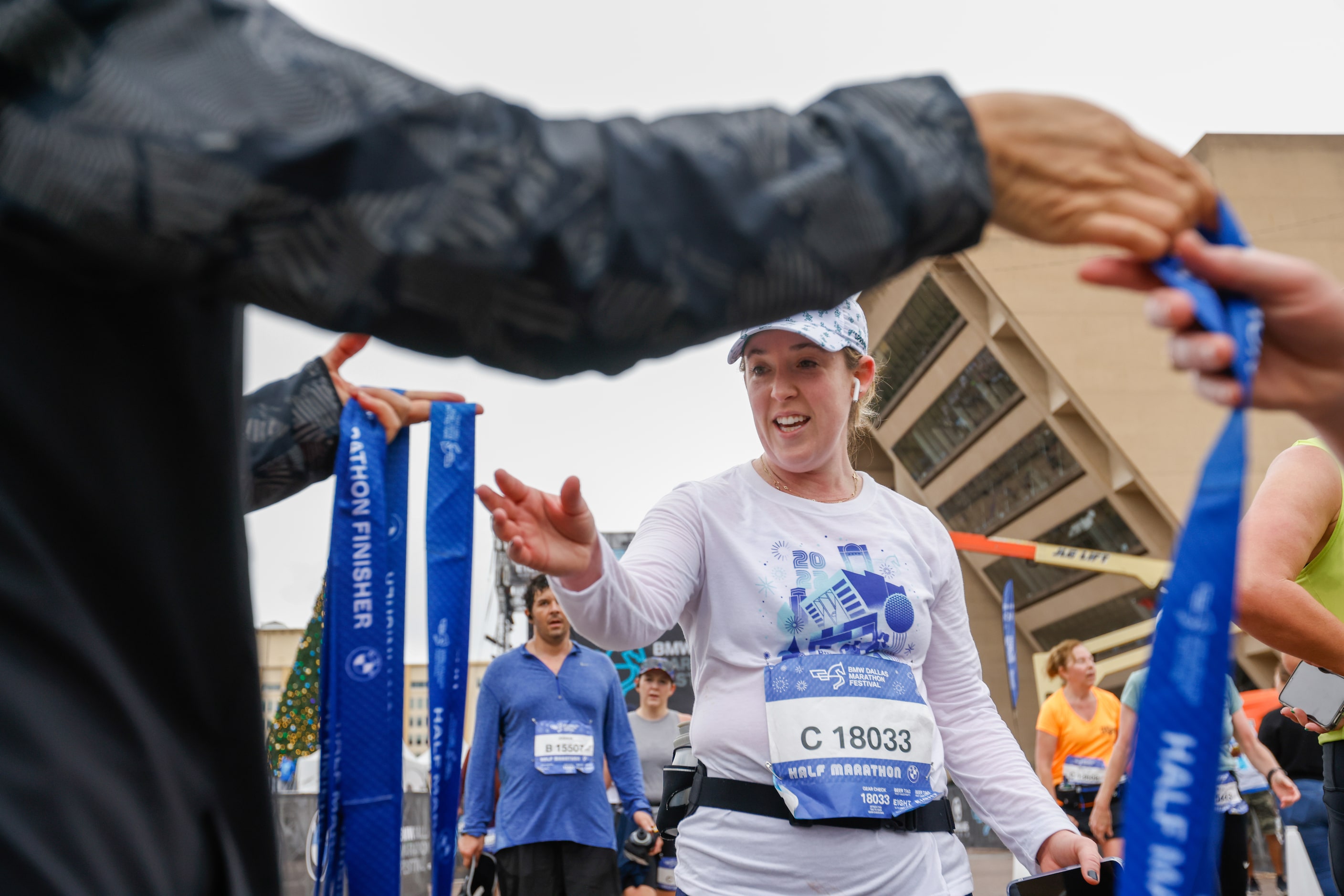 Candace Hupp reaches for her medal after completing the half-marathon at the BMW Dallas...