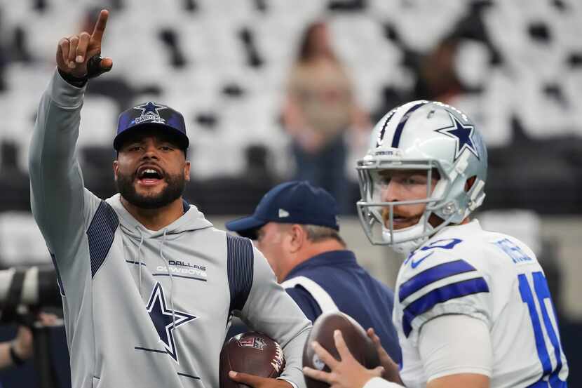Dallas Cowboys quarterback Dak Prescott (left) shouts encouragement to his teammates as...