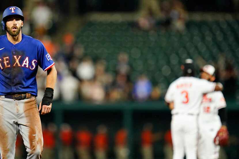 Texas Rangers' Steven Duggar, left, walks to the dugout as Baltimore Orioles shortstop Jorge...