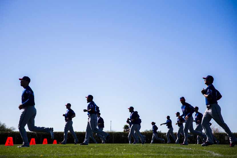 Texas Rangers pitchers and catchers warm up during a spring training workout at the team's...