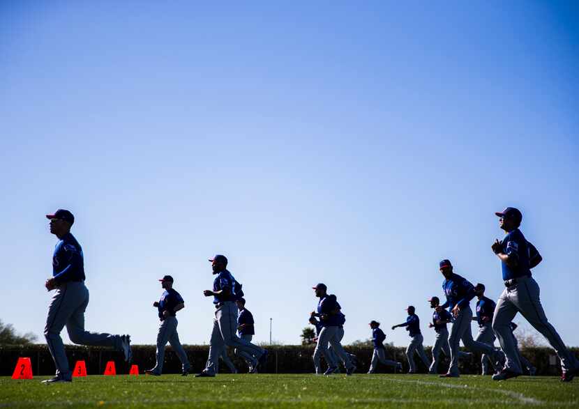 Texas Rangers pitchers and catchers warm up during a spring training workout at the team's...