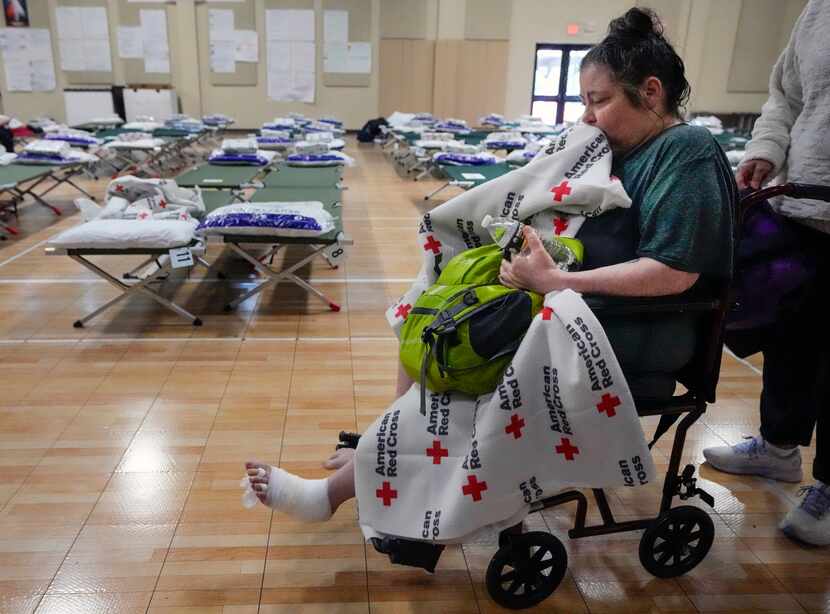 Crystal Williams sits in a wheelchair after receiving medical attention at a Red Cross...