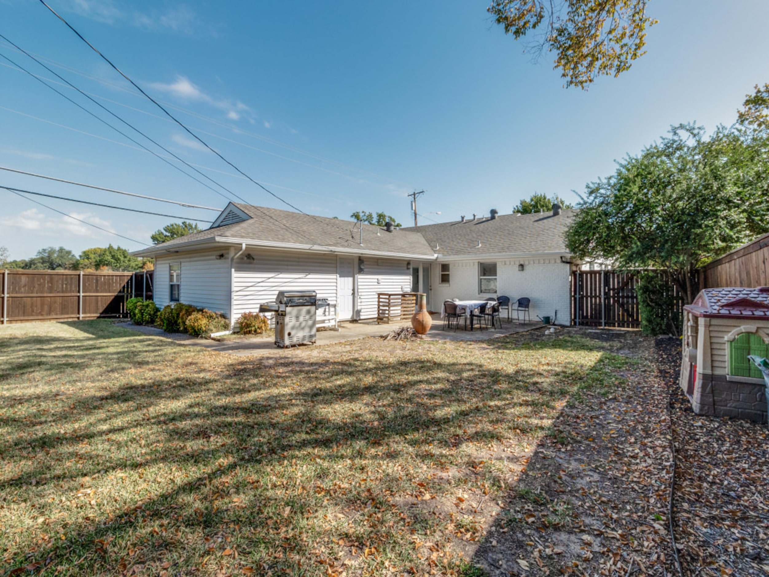 The backyard includes a patio and a grassy area.