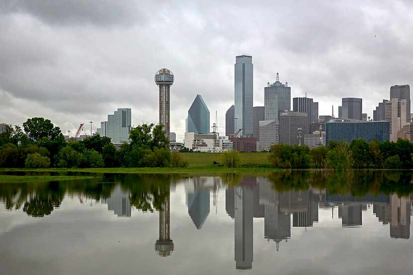 High waters from the Trinity River reflect the downtown skyline Monday, April 18, 2016 in...