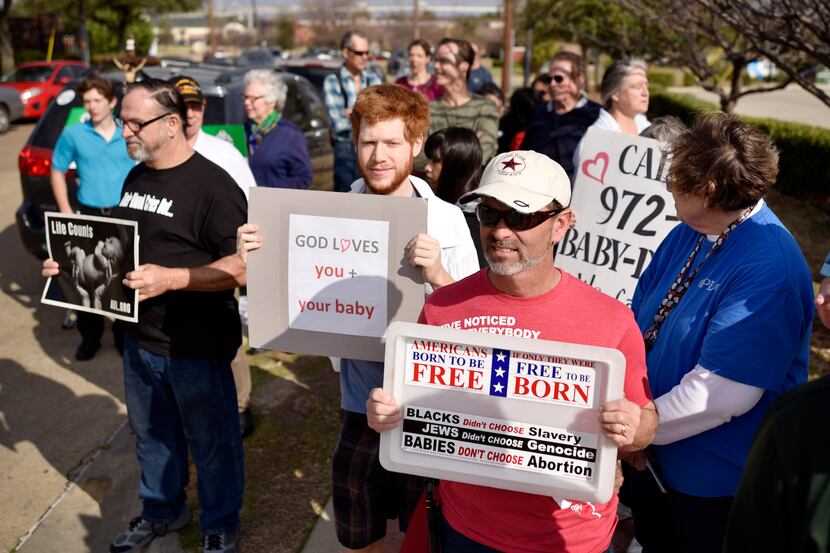 Abortion opponents Ethan Moon, 24, left, of Dallas, and Bobby Pope, 50, of Forney, hold...