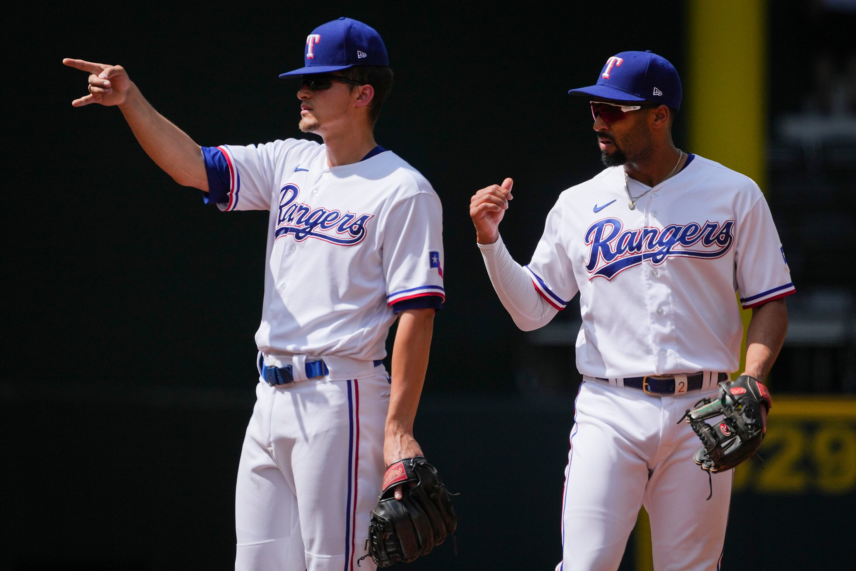 Texas Rangers second baseman Marcus Semien (right) and shortstop Corey Seager (5) look to...