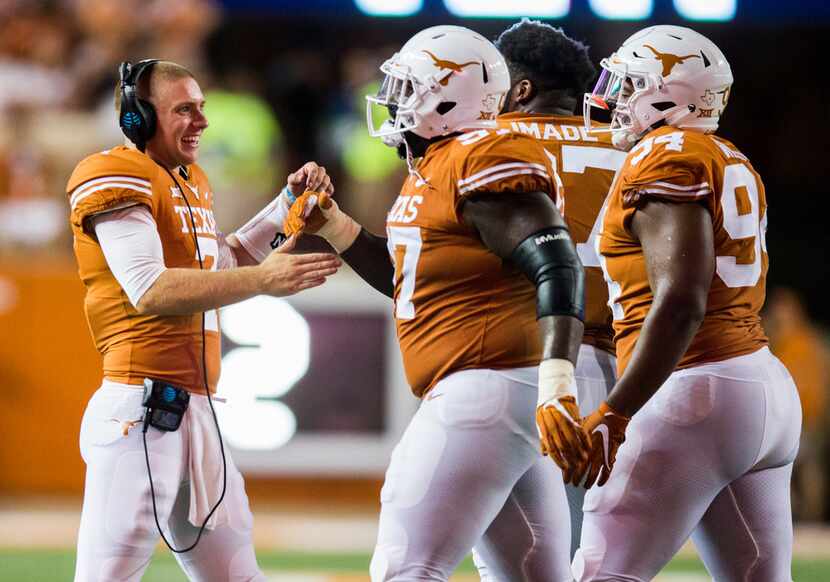 Ex-Texas Longhorns quarterback Shane Buechele (7) celebrates with teammates after a...