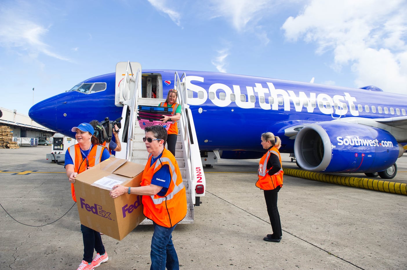 Volunteers assist with a special Southwest Airlines aid flight to transport about 60 dogs...