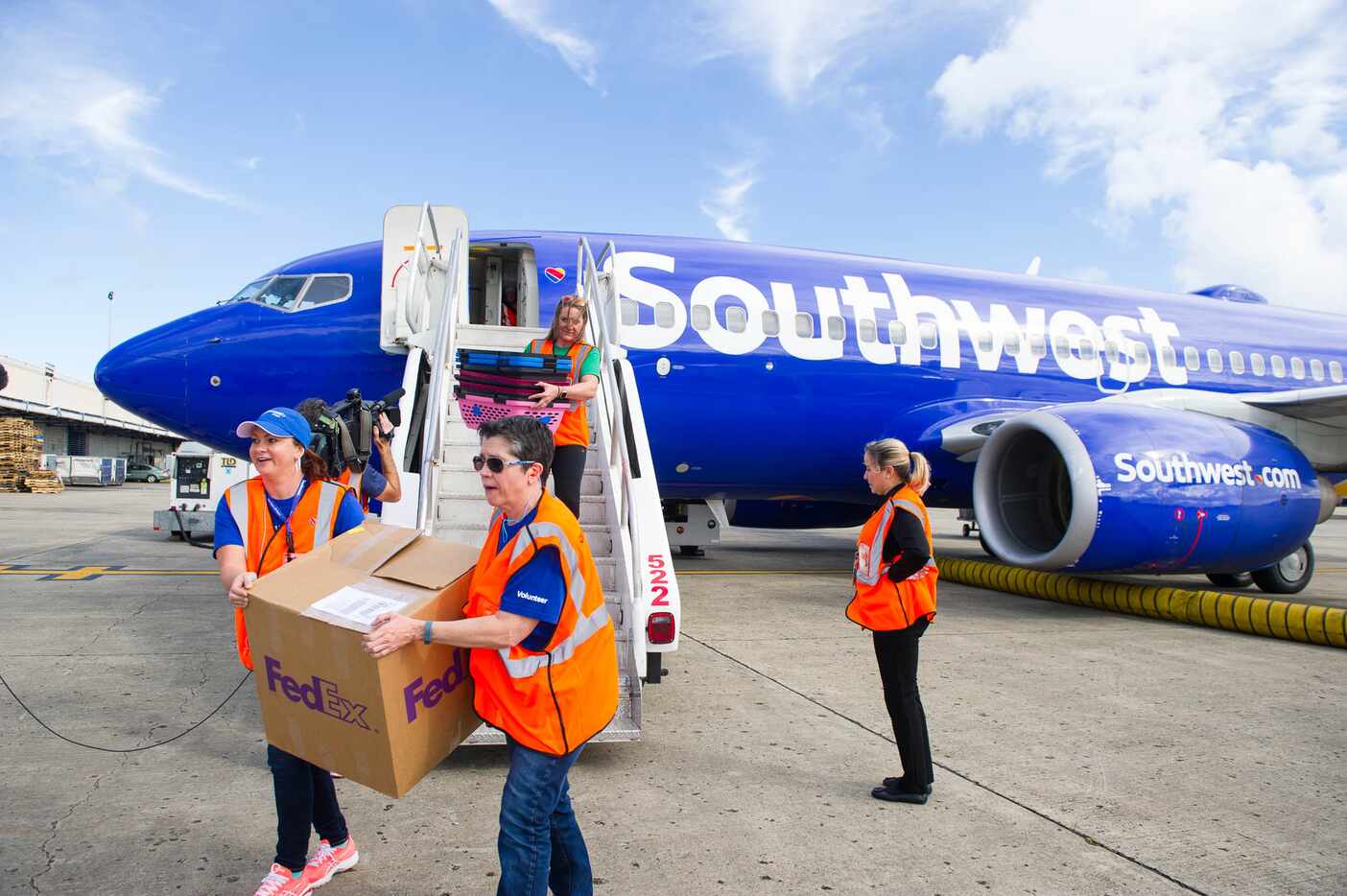 Volunteers assist with a special Southwest Airlines aid flight to transport about 60 dogs...