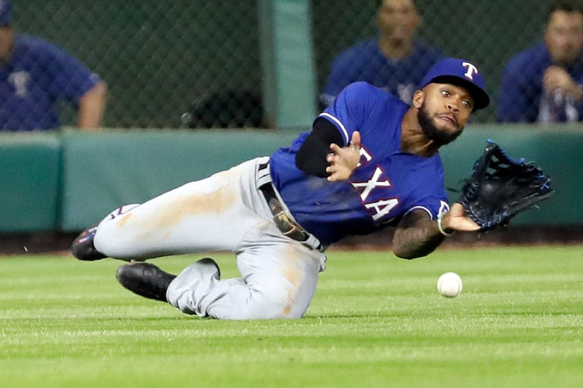 Texas Rangers left fielder Delino DeShields dives as he tries to catch an RBI double by...