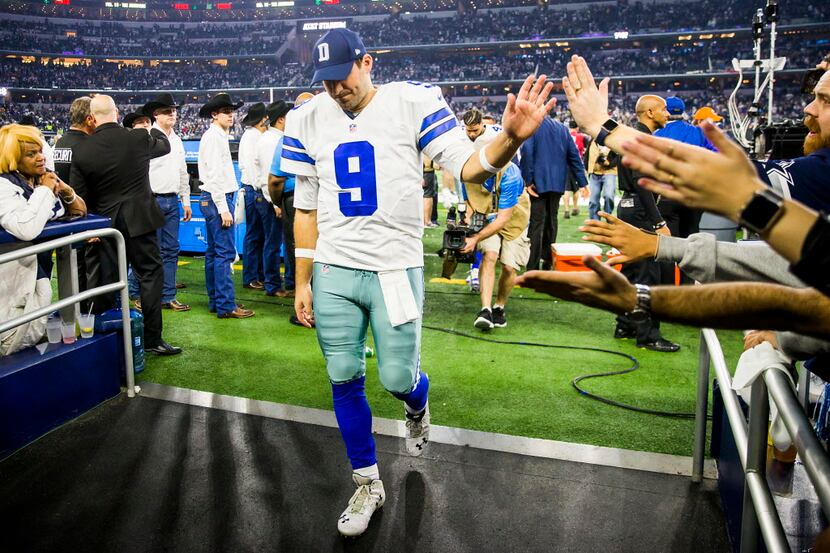 Dallas Cowboys quarterback Tony Romo high fives fans as walks off the field after the Green...