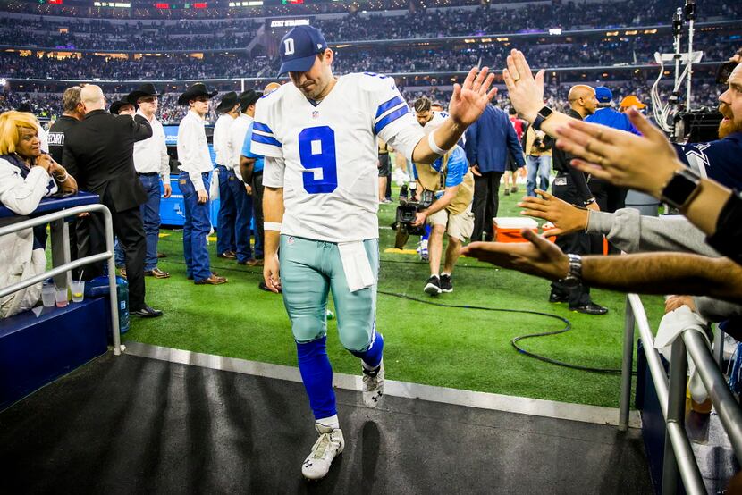 Dallas Cowboys quarterback Tony Romo high fives fans as walks off the field after the Green...