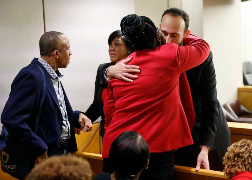 Assistant District Attorney Jason Fine (right) gives Botham Jean's mother, Allison Jean, a...