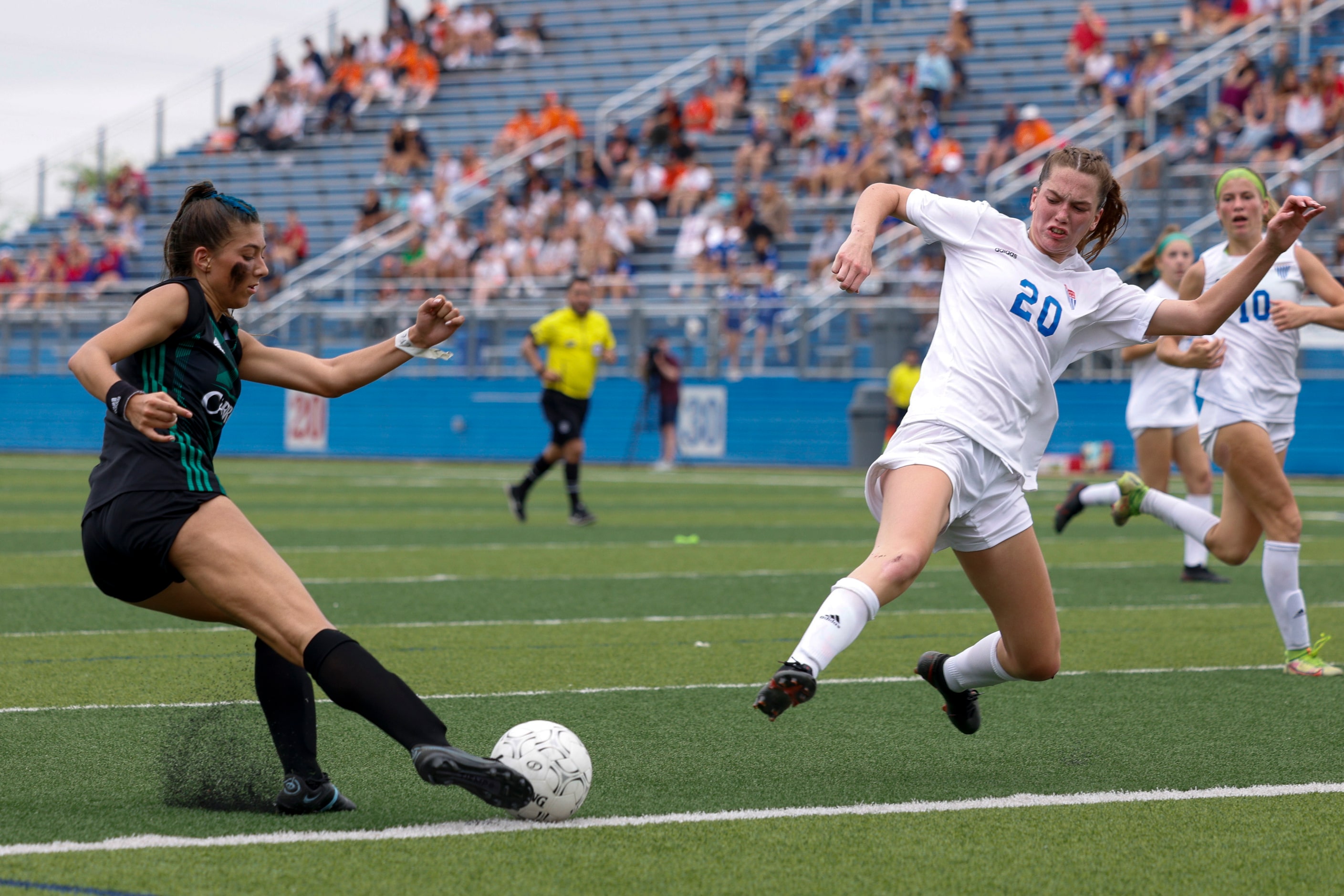 Southlake Carroll forward Madison Khan (5) crosses the ball ahead of a diving Austin...