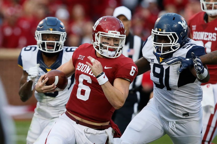 Oklahoma quarterback Baker Mayfield (6) carries past West Virginia safety Dravon Askew-Henry...