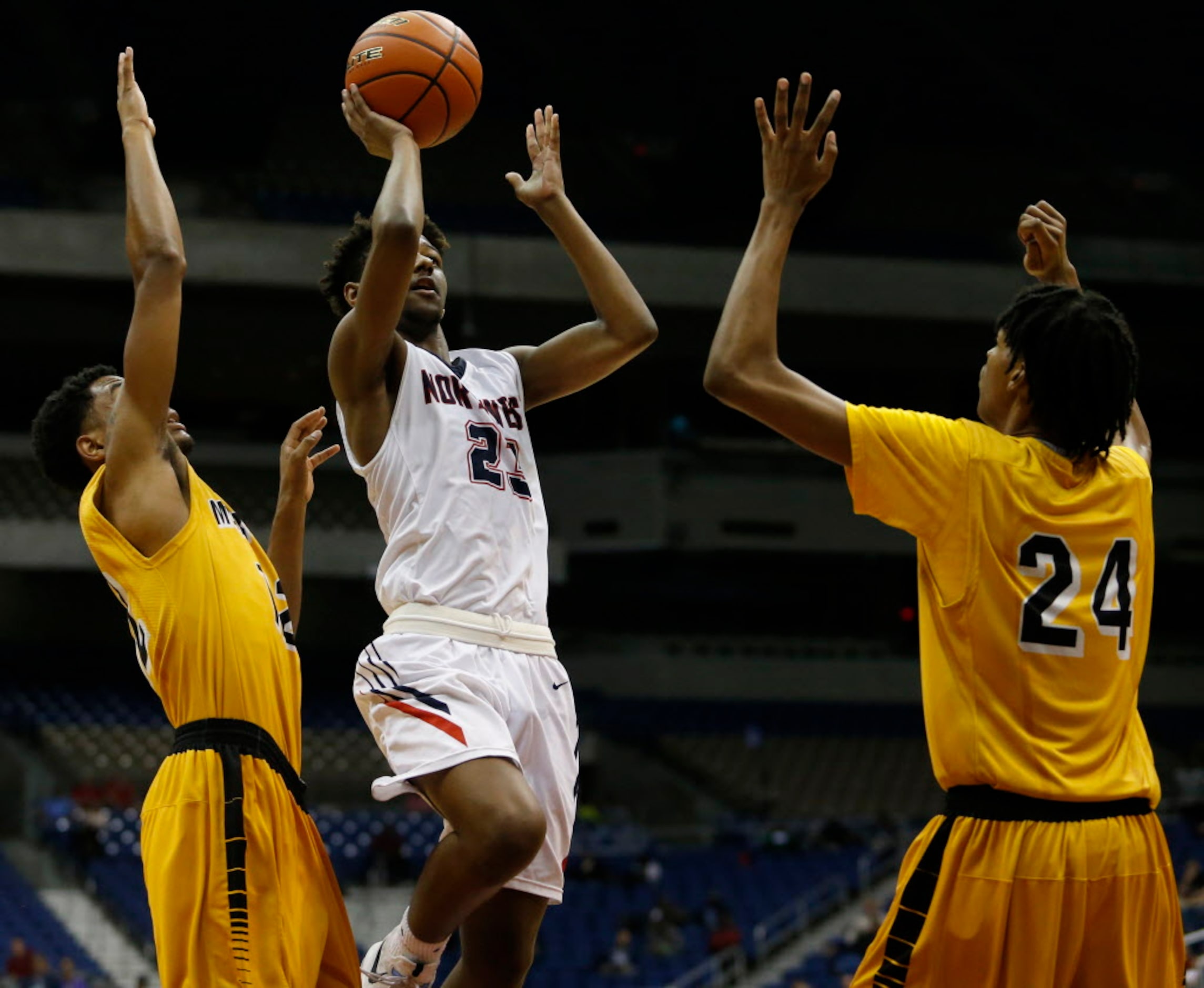 Justin Northwest's Julian Smith (23) goes to the basket between Fort Bend Marshall's Tajzmel...