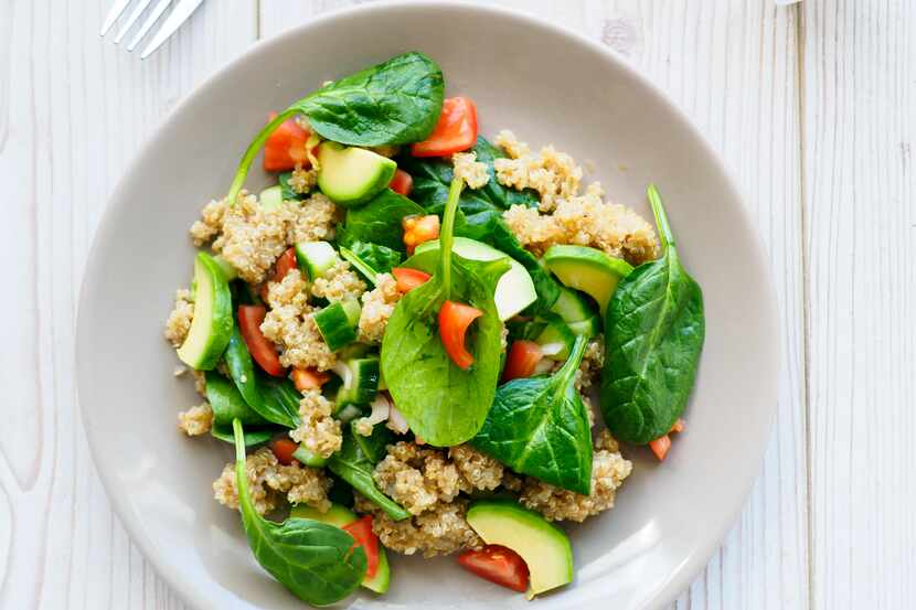 Quinoa salad with avocado, cucumber, spinach and tomatoes.