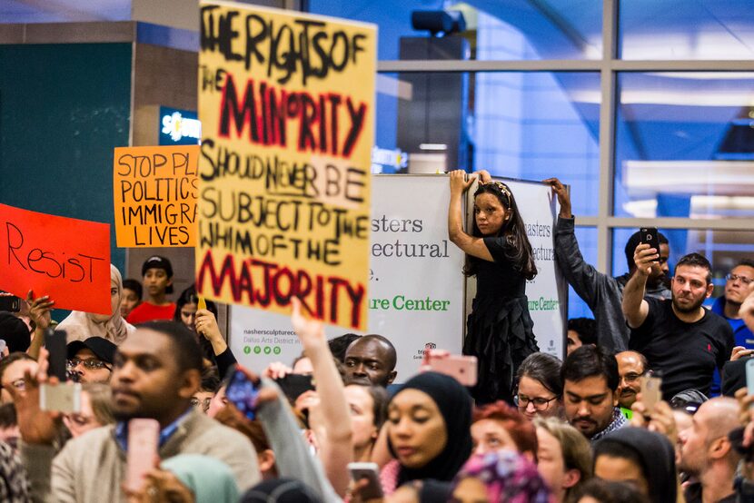 Protestors listen as organizers announce an end to the demonstration at DFW International...