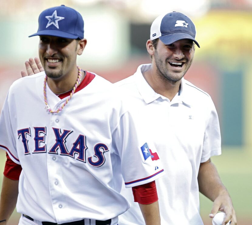 Dallas Cowboys quarterback Tony Romo shares a laugh with Texas Rangers relief pitcher Mike...