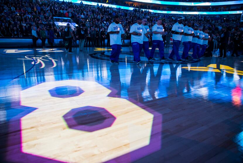 Mavs Maniacs hold candles during a tribute to former Los Angeles Laker Kobe Bryant and his...