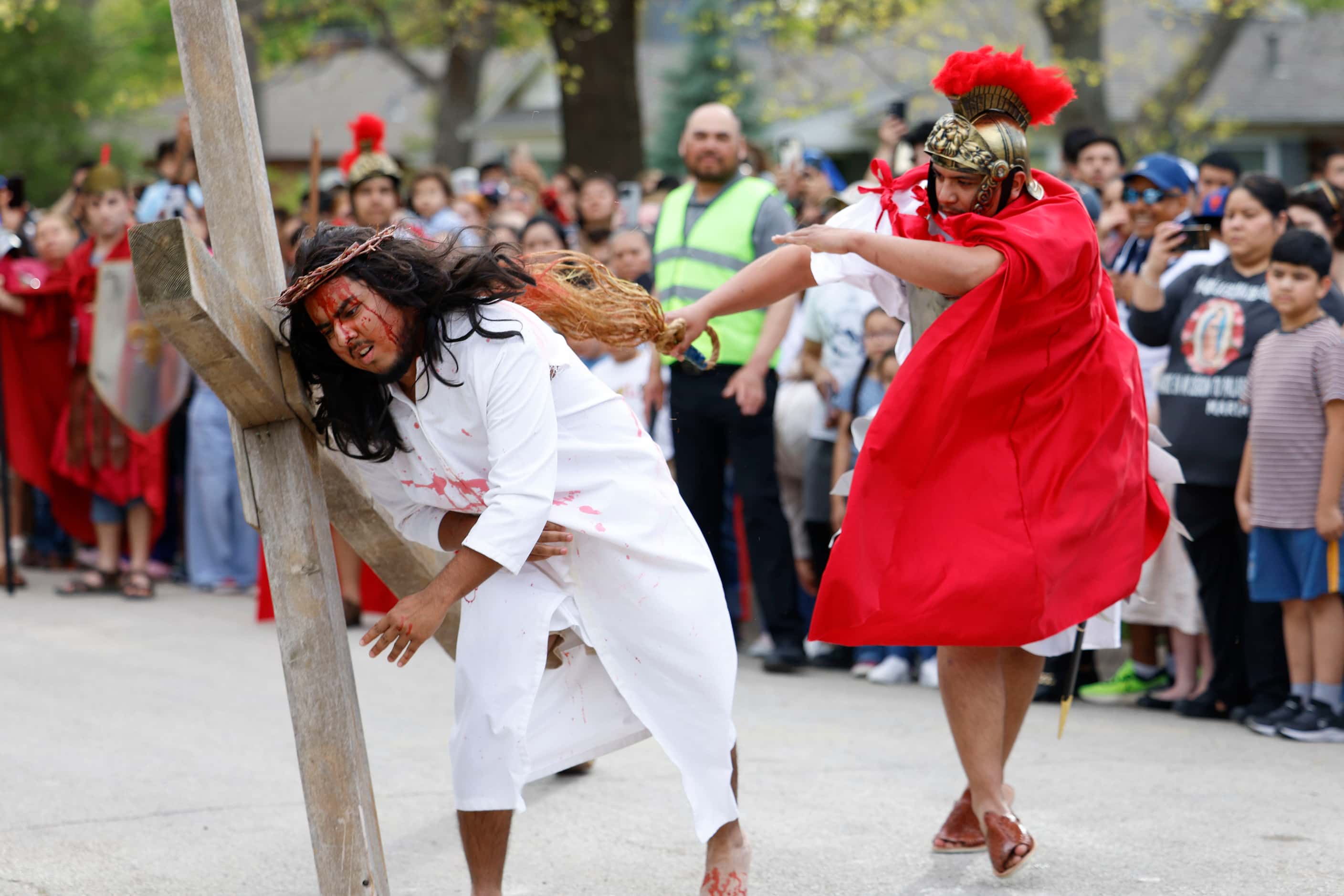 Bernie Gonzalez (left) reenact the sufferings of Jesus Christ during Living Stations of the...
