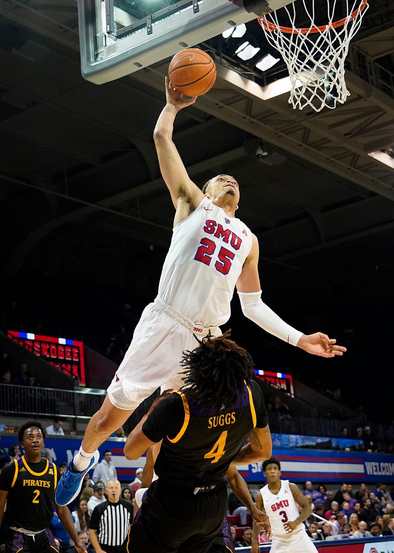 SMU forward Ethan Chargois (25) is fouled by East Carolina forward Brandon Suggs (4) as he...