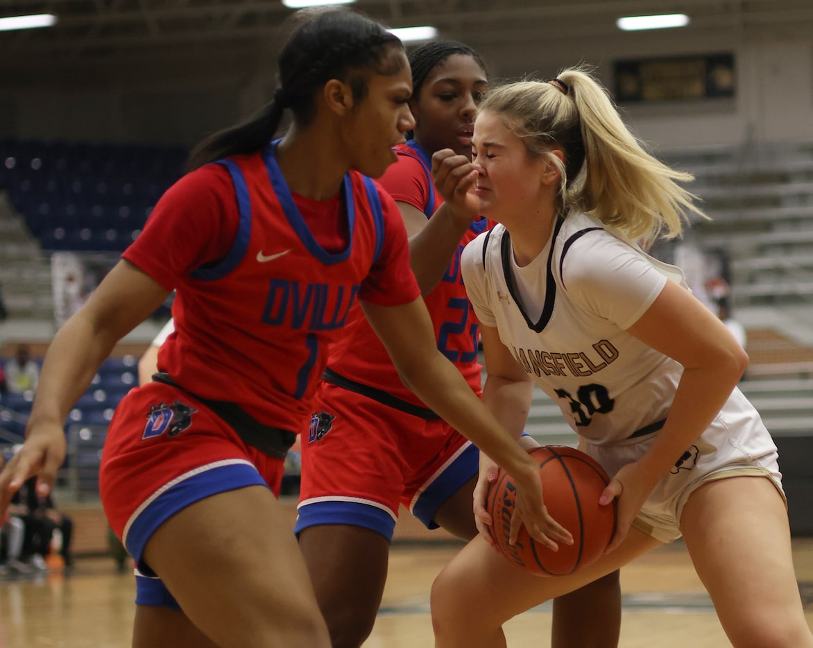 Mansfield guard Abby Bush (30), right, winces as she pulls down a rebound against the...