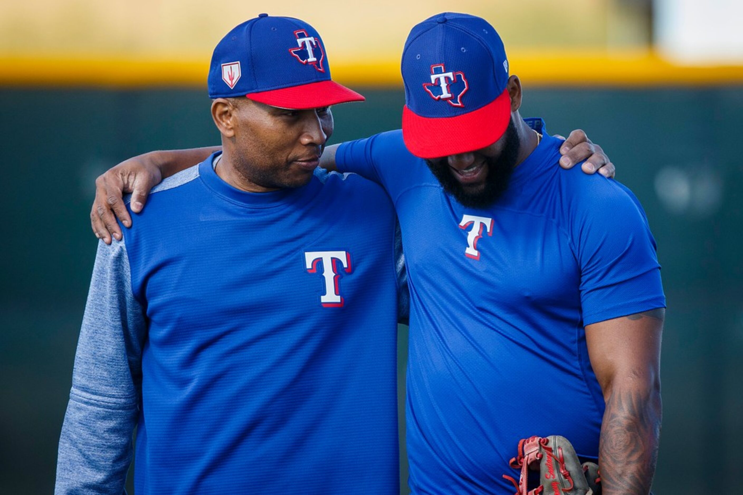 Texas Rangers third base coach Tony Beasley (left) walks arm in arm with outfielder Danny...