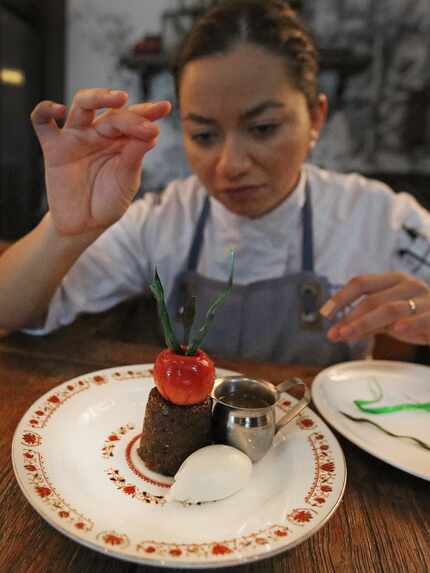 Pastry chef Marlene Duke puts the finishing touches on a toffee cake with crab apple.