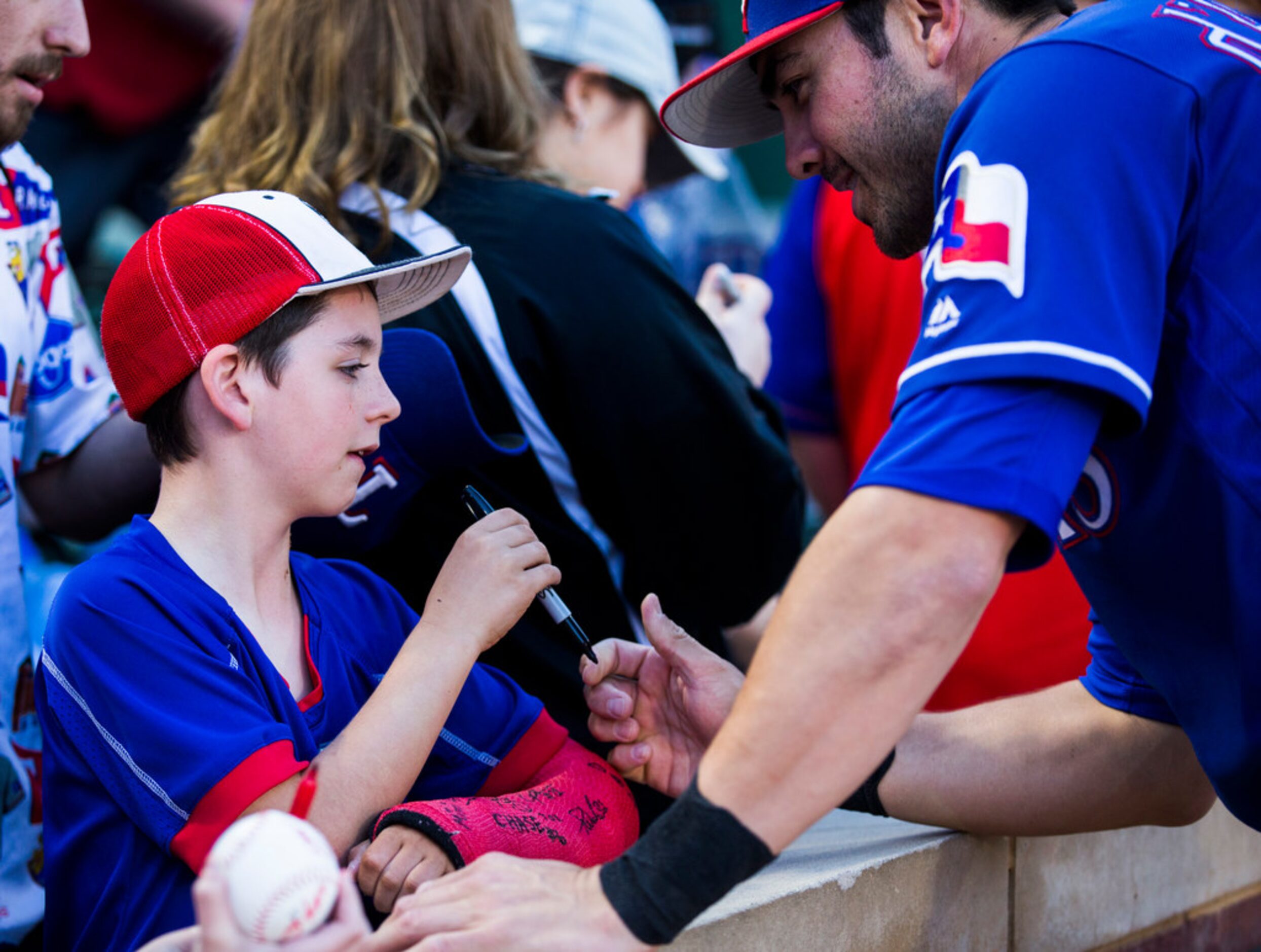 Texas Rangers infielder Chase d'Arnaud (6) signs the cast of Luke Hair, 9, of Burleson,...