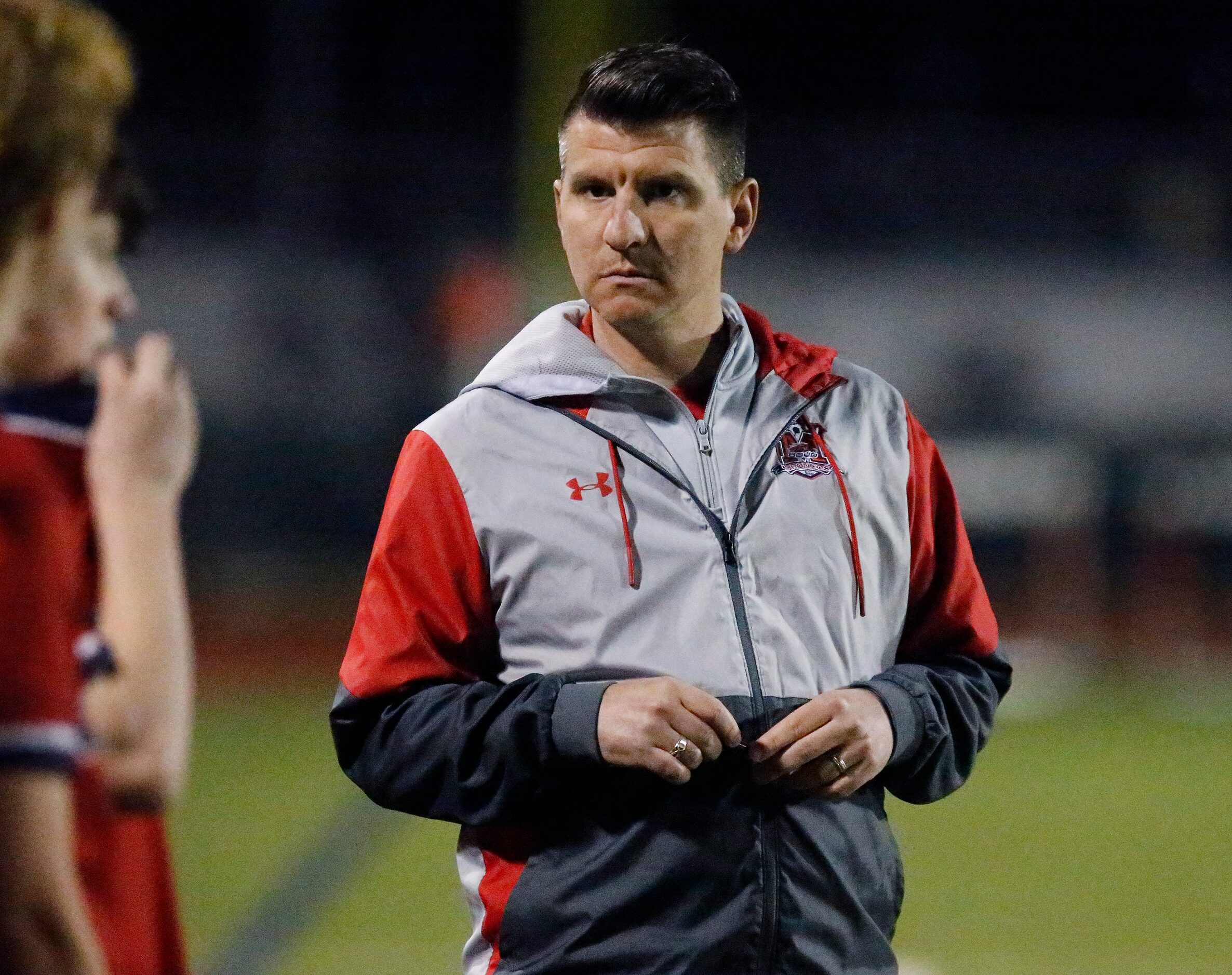 McKinney Boyd High School head coach Colby Peek walks the sideline before the start of the...